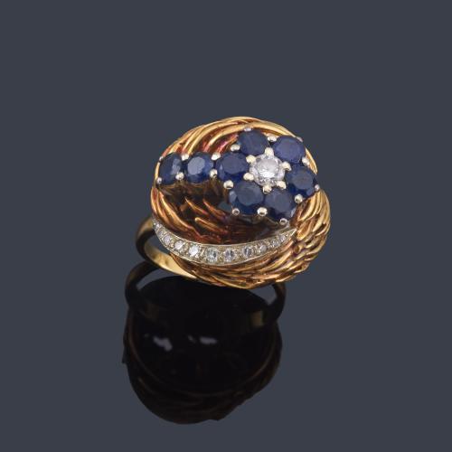  Anillo años '70 con centro floral de zafiros y brillante en montura en forma de cestillo de oro amarillo de 18K.