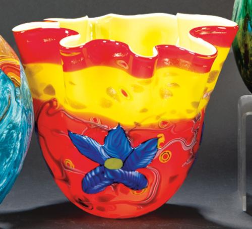 Lote 1445
Jarrón de Murano con boca rizada con rallas rojas y verdes con grandes flores azules en relieve.