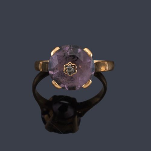 Lote 2049
Anillo con amatista facetada y centro con diamante talla rosa en montura de oro amarillo de 18K.