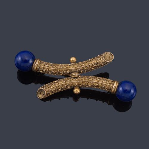 Lote 2057
Broche con dos cuentas esféricas de lapislázuli en montura de oro amarillo de 18K.