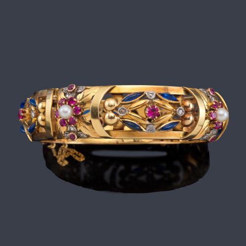 Lote 2106
Pulsera rígida años '40 con zafiros y rubíes sintéticos con perlitas en montura calada de oro amarillo de 18K.