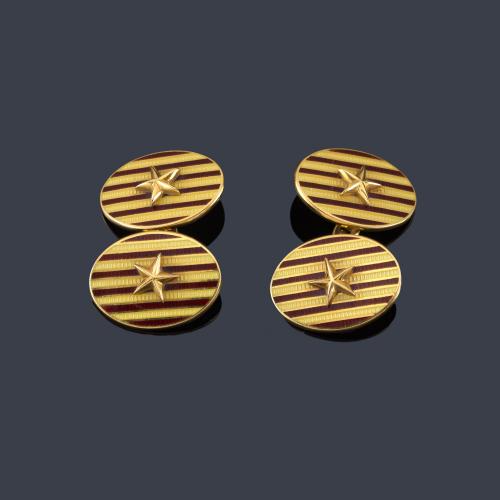 Gemelos ovalados con esmalte y una estrella de mar al centro, en montura de oro amarillo de 18K.