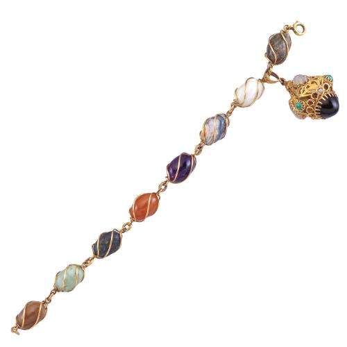 Lote 2292
Pulsera con gemas duras en montura de oro amarillo de 18K y colgante calado con turquesas, piedra luna y cuarzo.