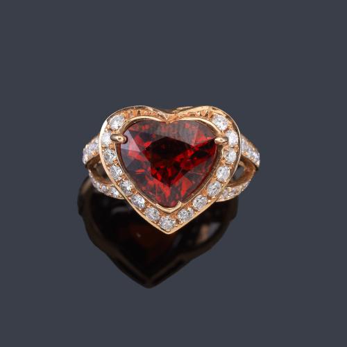 Lote 2298
Anillo con granate espesartina talla corazón de aprox. 4,78 ct con orla de brillantes de aprox. 0,81 ct en total.