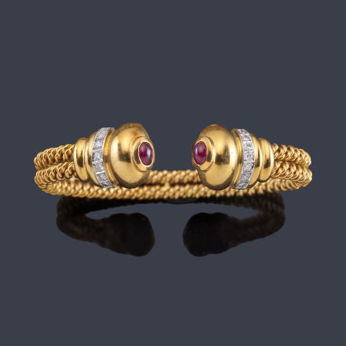 Lote 2372
Pulsera rígida con remate de dos rubíes talla cabujón y banda de brillantes en montura de oro amarillo de 18K.