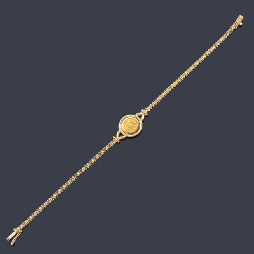 Lote 2487
Pulsera con moneda central en montura de oro amarillo de 18K.
