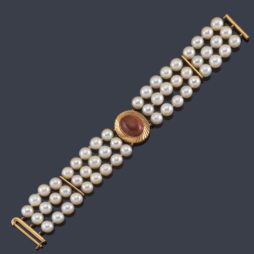 Lote 2504
Pulsera con tres hilos de perlas de aprox. 7,71 mm y centro de cuarzo aventurina sobre montura de oro amarillo de 18K.