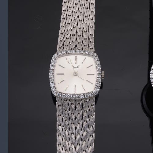Lote 2558
PIAGET de señora con caja y brazalete en oro blanco de 18 K con orla de brillantes.