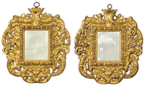 Lote 1072
Pareja de marcos de espejo de perfil irregular con profusa decoración en madera tallada y dorada, rematados por aves coronadas.
España, S. XVII