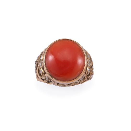 Anillo con coral central talla cabujón en montura de oro rojo de 18K con diseño vegetal enriquecido con diamantes talla 8/8. Ppios S. XX.