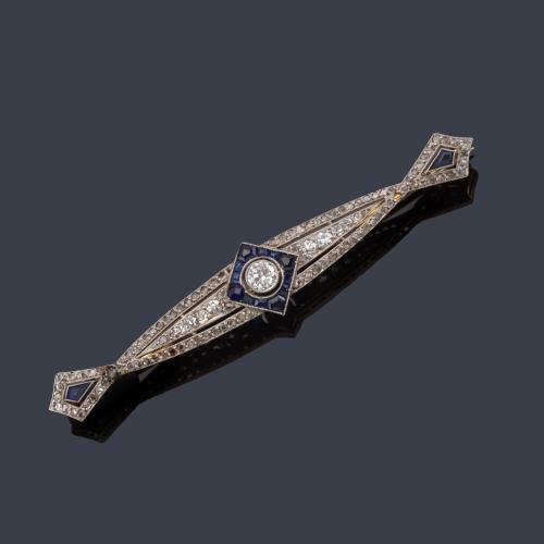 Broche-barrita 'art decó' con diamante talla antigua de aprox. 0,45 ct con orla de zafiros calibrados. Circa 1930.