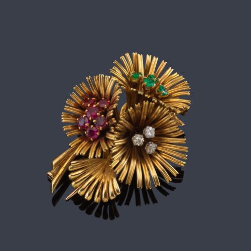 Broche con diseño floral años '70 con centro cuajado de esmeraldas, rubíes y brillantes en hilos de oro amarillo de 18K.