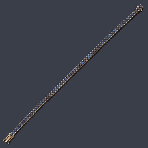  Pulsera rivière con zafiros calibrados de aprox. 10,00 ct en total en montura de oro amarillo de 18K.