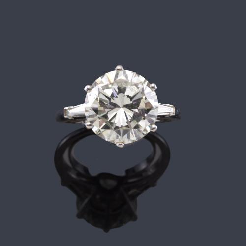 Solitario con brillante de aprox. 5,05 ct con un diamante talla trapecio a cada lado.