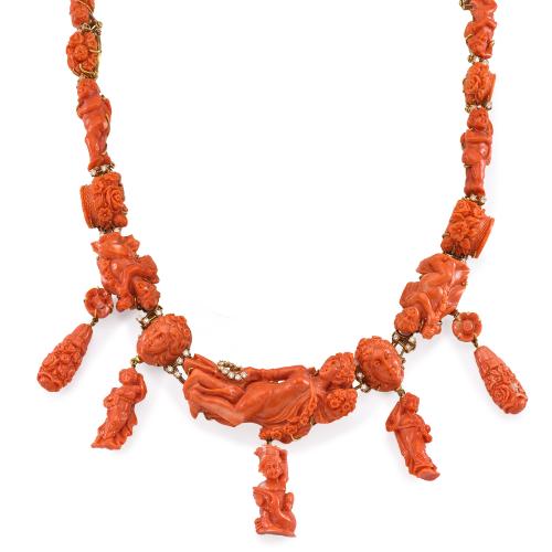  Destacado collar con piezas de coral tallado y brillantes montado en oro amarillo de 18K.