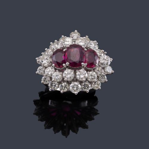 Anillo con tres rubíes talla oval de aprox. 2,70 ct con doble orla de brillantes de aprox. 3,88 ct en total.