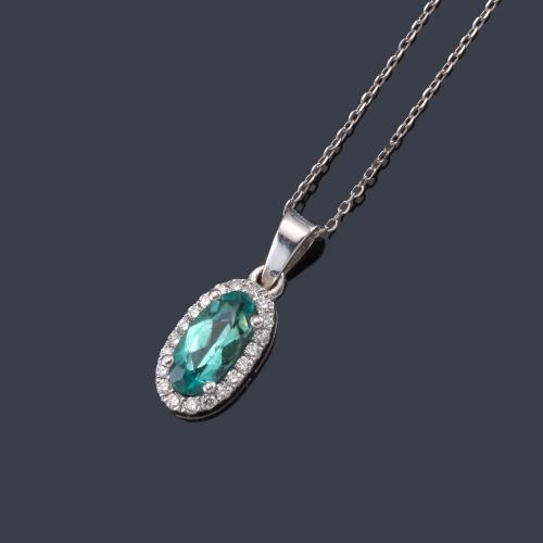  Colgante con turmalina Paraiba talla oval de aprox. 0,60 ct y orla de brillantes de aprox. 0,10 ct en total.