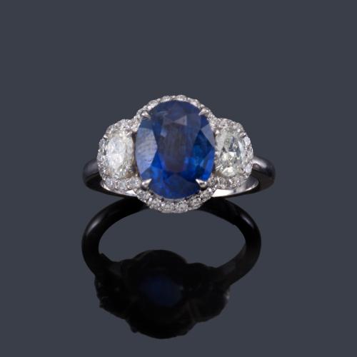  Anillo con zafiro talla oval de aprox. 3,44 ct y orla de brillantes de aprox. 0,35 ct en total y dos diamante talla oval de aprox. 0,55 ct en total. Certificado Bellerophon Gemlab.