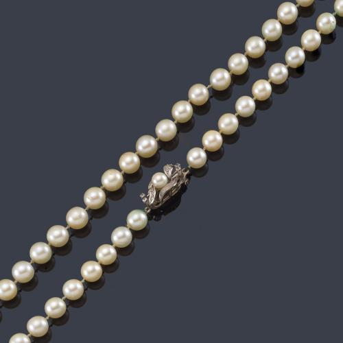 Collar con un hilo de perlas de aprox. 8,00 mm con cierre de diseño vegetal con una perlita y piedras incoloras, en montura de oro blanco de 18K.