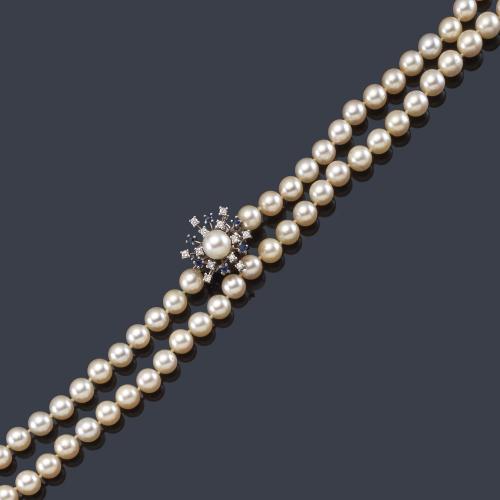 Collar largo con hilo de perlas de aprox. 7,00 - 8,00 mm con cierre en oro blanco de 18K salpicado con brillantes de aprox. 0,48 ct y zafiros talla redonda de aprox. 0,48 ct en total y perla central.