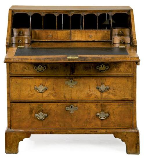  Bureau Jorge II en madera de nogal, con tapa abatible que al abrirse revela un interior con superficie para escribir y una serie de cajones y compartimentos, sobre dos cajones cortos y dos largos