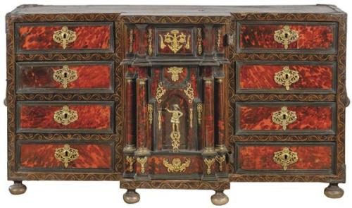  Bargueño Carlos II en madera de nogal, mnadera ebonizada y carey, con monturas de bronce. Con una portada central de puerta abatible flanquea 4 cajones a cada lado. España, finales S. XVII