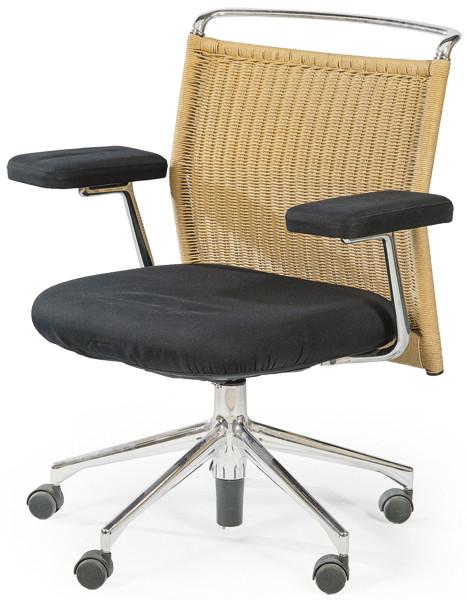  Butaca de escritorio con estructura de metal cromado, con asiento y reposabrazos tapizados en tela negra y respaldo de ratán trenzado.