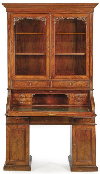  Buró boockase victoriano en madera de caoba, con dos puertas superiores abatibles y acristaladas con baldas internas, debajo un escritorio con tapa abatible sobre dos pedestales. Inglaterra, segunda mitad S. XIX