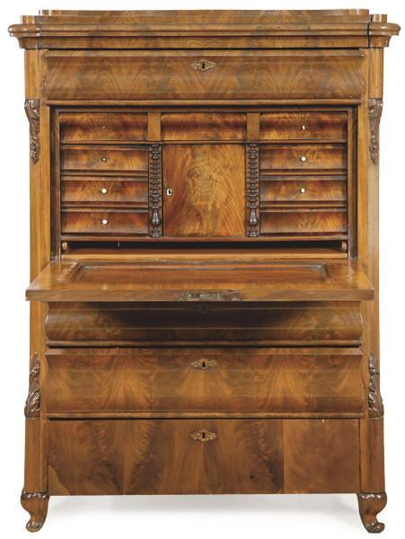  Secretaire “a abattant” biedermeier en madera de caoba y palma de caoba tallada, con puerta abatible que al abrirse revela un interior con cajones, compartimentos y una superficie para escribir.Alemania, mediados S. XIX