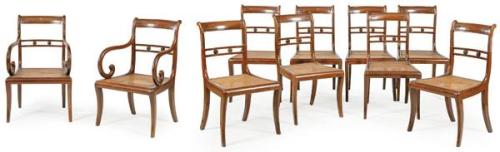  Conjunto de ocho sillas y dos butacas Regencia en madera de caoba tallada con patas tipo sable.