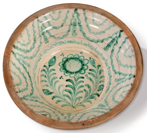 Lebrillo en cerámica esmaltada verde de fajalauza con decoración de girasol en el asiento y cenefa a modo de cortinaje en el alero. 