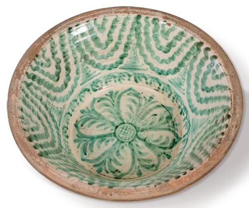 Lebrillo en cerámica esmaltada verde de fajalauza con decoración de flor central en el asiento y cenefa a modo de cortinaje en el alero. 