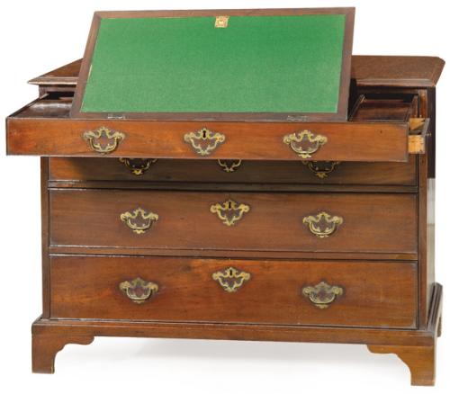 Cómoda escritorio Jorge II en madera de caoba con tiradores y escudos de cerradura en bronce. El cajón superior al abrirse se convierte en un escritorio con tapa abatible, cajones secretos y compartimentos. Inglaterra segundo tercio S. XVIII
