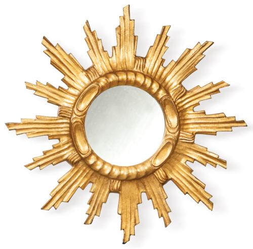  Espejo en madera tallada y dorada con marco en forma de sol con rayos concéntricos.