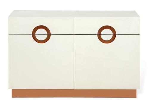 Aparador en madera lacada en blanco y latón, con dos cajones cortos sobre puertas abatibles, con tiradores circulares recortados.