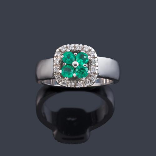  Anillo con cuatro esmeraldas talla redonda con orla de brillantes en montura de oro blanco de 18K.