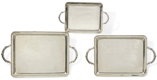 Juego de tres bandejas de plata con marcas no identificadas con asa y borde sogueados, de distintos tamaños.