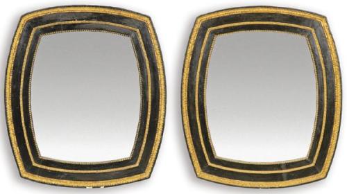  Pareja de marcos de espejo con cuatro lados ligeramente convexos en madera tallada, pintada de negro y parcialmente dorada.