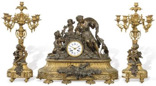  Reloj de sobremesa con guarnición de candelabros Napoleón III estilo Luis XVI en bronce dorado y pavonado. Maquinaria francesa del tipo "París", con sonería de horas y medias.Francia, segunda mitad S. XIX