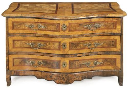  Cómoda barroca de frente sinuoso en madera de nogal y raíz de nogal, con tiradores y escudos de cerradura en bronce.