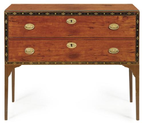  Cómoda Regencia con dos cajones largos enmarcados por una greca de motivos geométricos en marquetería de limoncillo, sobre patas rectas y estrechas. Escudos de cerradura y tiradores en latón.