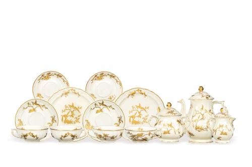 Juego de té de 18 servicios Reine Elisabeth, en porcelana Bernardaud & Compañía de Limoges, con fondo crema decorado con vegetación y pájaros del paraiso en dorado.