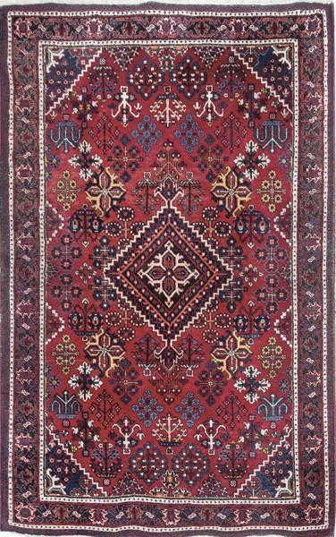  Alfombra pesa en lana con campo rojo con medallón romboidal y decoración geométrica y de flores esquemáticas.