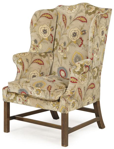 Butaca wingback estilo chippendale, con tapicería de tela de flores, sobre patas rectas unidas por chambranas.