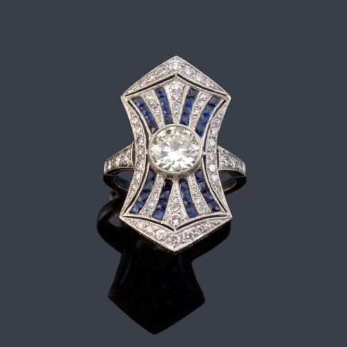 Anillo lanzadera con brillante central de aprox. 1,03 ct con bandas de zafiros calibrados de aprox. 1,00 ct intercalado con brillantes de aprox. 0,70 ct en total.