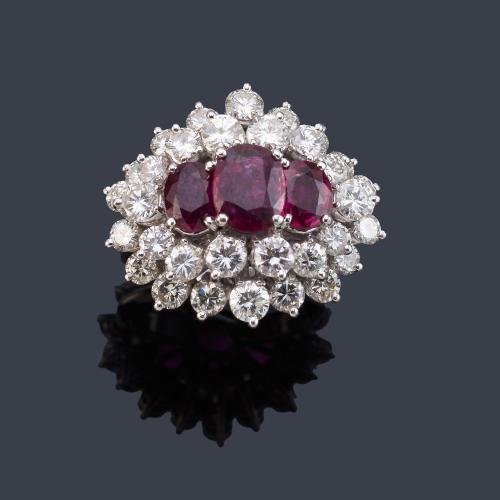 Anillo con tres rubíes talla oval de aprox. 2,70 ct con doble orla de brillantes de aprox. 3,88 ct en total.