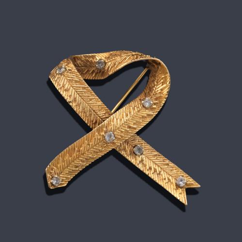 Broche en forma de lazada con diseño rallado salpicado de piedras incoloras.