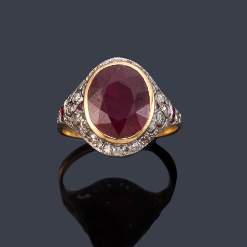Anillo con rubí talla oval de aprox. 6,30 ct en montura calada con diamantes talla 8/8 en oro amarillo de 18K y oro blanco.