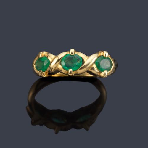 Anillo con tres esmeraldas talla oval en montura de oro amarillo de 18K.
