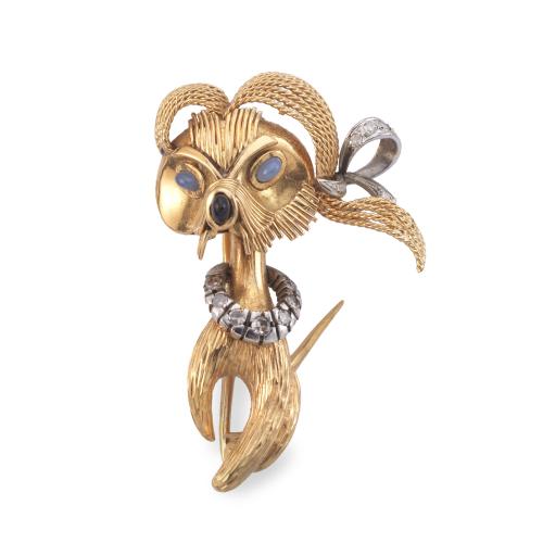 Broche con diseño de perrito con diamantes y zafiro, en montura de oro amarillo de 18K y motivos en platino.